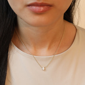 Model draagt een 14 karaat gouden ketting met ovale diamant van 0.3 karaat